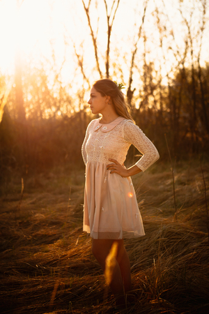 portrait of a girl in a field on a sunset background.の写真素材