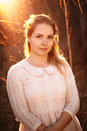 portrait of a girl in a field on a sunset background.の写真素材