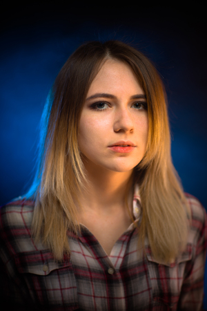 portrait smiling girl on blue background in studio.の写真素材