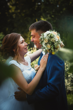 couple groom and bride hugging and kissing on nature park background.の写真素材