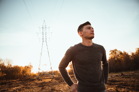 portrait of a guy in the field on a sunset background.の写真素材