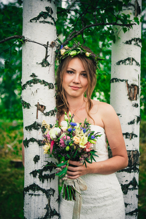 Young bride near birches in the forest.の写真素材