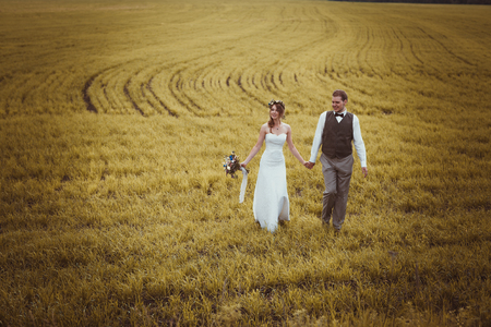 bride and groom stand on the background of the field.の写真素材