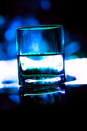 colored lighting of glasses in the night club bar.