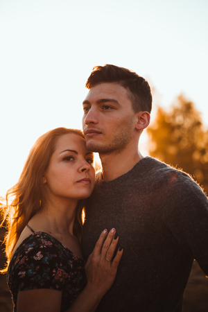 guy and girl in the field on the sunset background.の写真素材