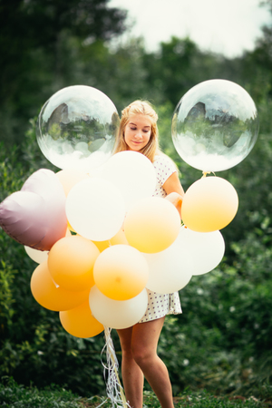 young girl with balloons on nature background.の写真素材