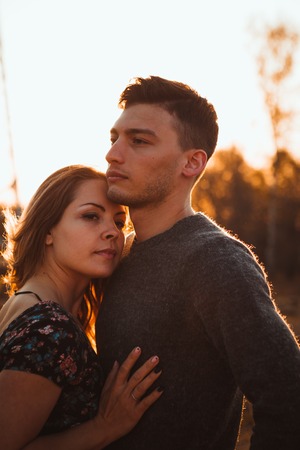 guy and girl in the field on the sunset background.