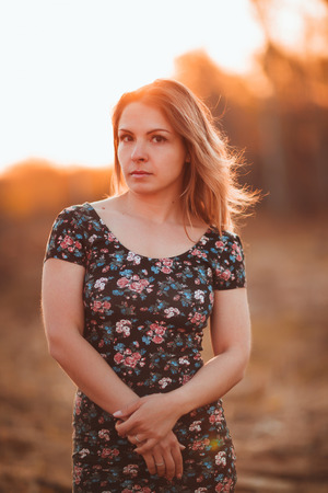 portrait of a beautiful girl in a field on a sunset background.の写真素材