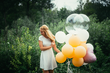 young girl with balloons on nature background.の写真素材