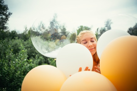 portrait of young girl with balloons on nature background.の写真素材