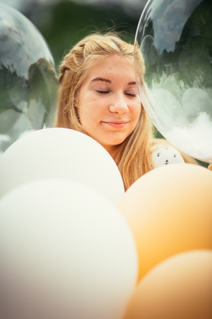 portrait of young girl with balloons on nature background.の写真素材