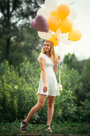 young girl with balloons on nature background.の写真素材