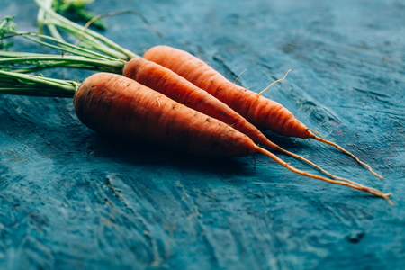 Fresh carrots on a blue wooden background.の写真素材
