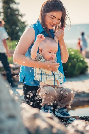 happy mother and toddler son near the fountain.の写真素材