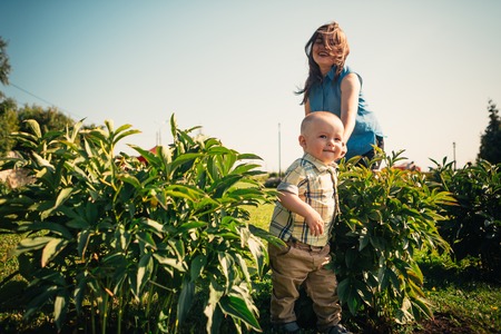 happy mother and toddler son on nature background.の写真素材