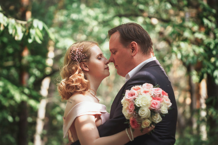 bride and groom on the background of trees and forest sun.の写真素材