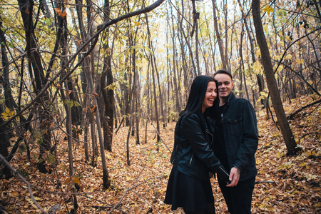 The girl and the guy are walking in the autumn forest.の写真素材