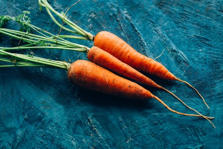 Fresh carrots on a blue wooden background.の写真素材