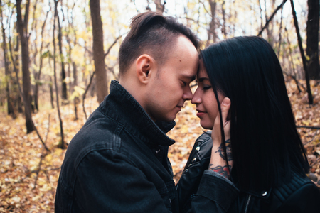 portrait of a young woman and a man walking in the autumn forest.の写真素材