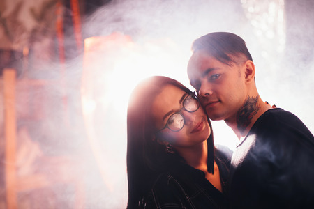 Couple in fashionable clothes on a shiny background.の写真素材