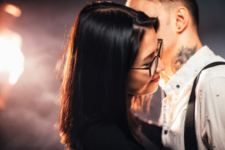 portrait couple in fashionable clothes on a dark smoky background.の写真素材