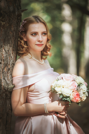 portrait of a beautiful bride standing near a tree.の写真素材