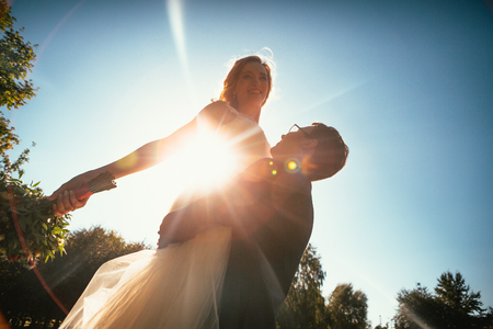 Dancing young bride and groom sunlight background.の写真素材