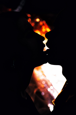 silhouette couple in fashionable clothes on a shiny background.の写真素材