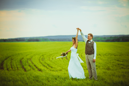 bride and groom stand on the background of the field.の写真素材