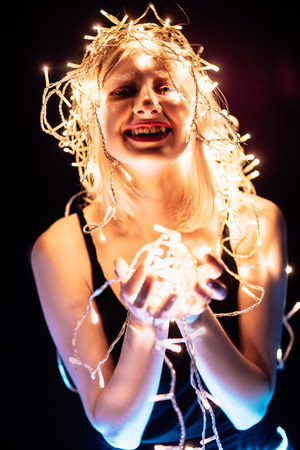 portrait of a girl with a garland on black background.の写真素材