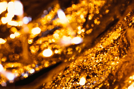 gold and silver bokeh on a dark background.の写真素材