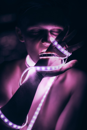 Portrait man Strip Light LED tape on dark color background.の写真素材