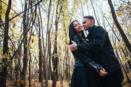 The girl and the guy are walking in the autumn forest.の写真素材
