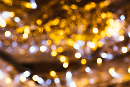 gold and silver bokeh on a dark background.の写真素材