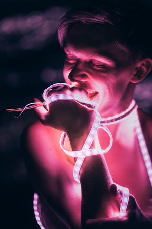 Portrait man Strip Light LED tape on dark color background.の写真素材