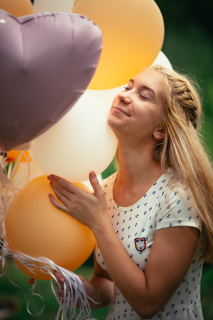 young girl with balloons on nature background.の写真素材