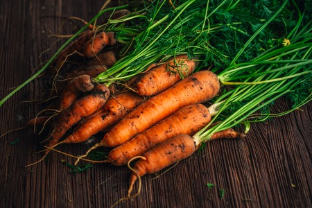 Fresh carrots close-up on a wooden background.の写真素材