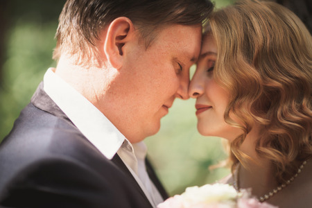 bride and groom kiss on the background of trees and forest.の写真素材