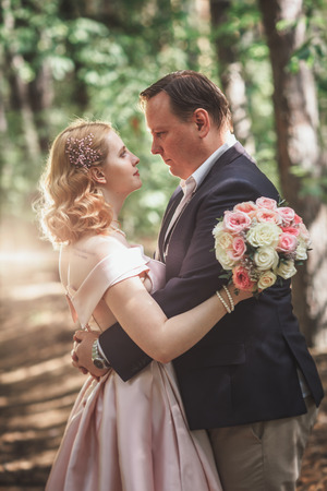 bride and groom on the background of trees and forest sun.の写真素材