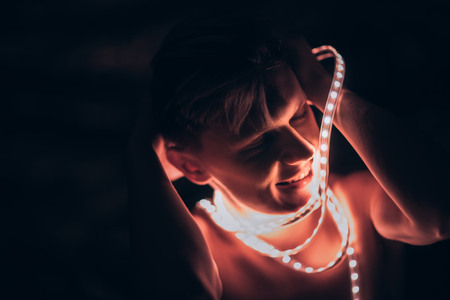 Portrait man Strip Light LED tape on dark color background.の写真素材