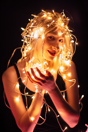 portrait of a girl with a garland on black background.の写真素材