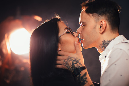 portrait couple in fashionable clothes on a dark smoky background.の写真素材