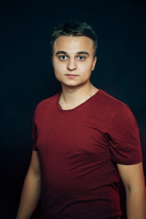portrait of a young man on a dark background.の写真素材