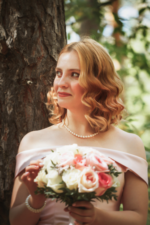 portrait of a beautiful bride standing near a tree.の写真素材