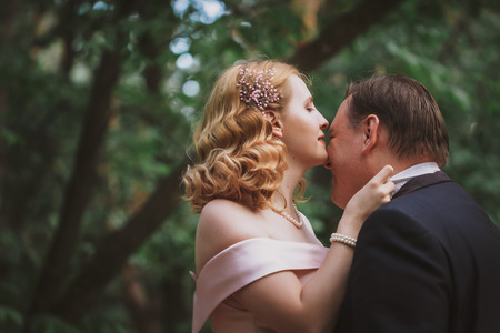 bride and groom kissing in the summer forest.の写真素材