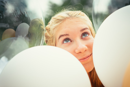 portrait of young girl with balloons on nature background.の写真素材