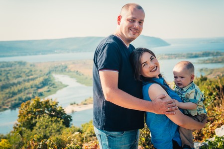 Happy family with baby son on nature background.の写真素材