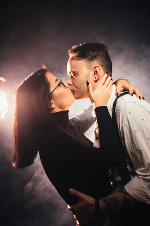 Couple in fashionable clothes on a dark smoky background.の写真素材