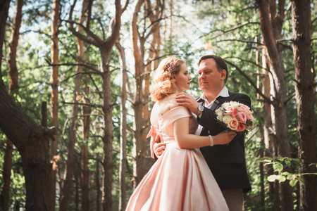 bride and groom on the background of trees and woods in full growth.の写真素材