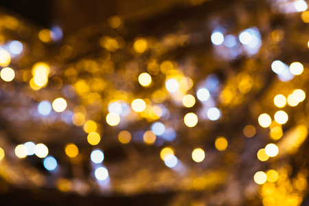 gold and silver bokeh on a dark background.の写真素材